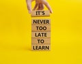 Its Never to Late to Learn symbol. Wooden blocks with words Its Never to Late to Learn. Beautiful yellow background. Businessm Royalty Free Stock Photo