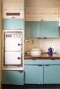 !960s Retrofitted blue kitchen in disrepair with electric oven. Royalty Free Stock Photo