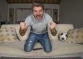 30s or 40s football fan man watching soccer game celebrating his team scoring goal crazy happy screaming cheering his team sitting Royalty Free Stock Photo