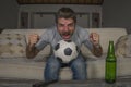 30s or 40s football fan man watching soccer game celebrating his team scoring goal crazy happy screaming cheering his team sitting Royalty Free Stock Photo