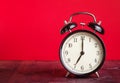 It`s seven o`clock already, time to wake up for love, vintage old black metallic alarm clock on red background Royalty Free Stock Photo