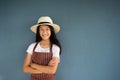 11s smiling young pretty girl portrait in summer hat and striped brown overall with blue cement wall Royalty Free Stock Photo