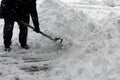 It`s snowing in a city and a person is clearing the roads with a shovel