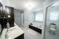 1950`s style bathroom with tile floor and dark brown cabinets in white and blue accents Royalty Free Stock Photo