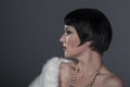 1920s style brunette dancer with short hair and jewelry. She is