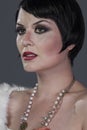 1920s style brunette dancer with short hair and jewelry. She is