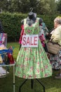 1940s style green floral dress with sale sign on a mannequin on outdoor market stall vendor