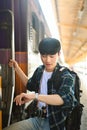 It's time to get on the train. Traveler male with backpack checking time on wrist watch and getting on the train Royalty Free Stock Photo