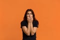 It`s very scary. Nervous scared caucasian woman in black t-shirt bites nails and looks with worried expression at camera, looks Royalty Free Stock Photo