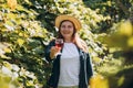 30s Woman in hat tasting red wine in vineyard. Portrait of pretty young woman holding glass of wine. Happy vintner Royalty Free Stock Photo