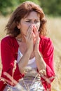 50s woman sneezing for rhinitis,allergies or hay fever Royalty Free Stock Photo