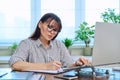 40s woman working with computer papers, remote workplace in home office Royalty Free Stock Photo