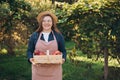 30s young woman in a hat is picking red apples in a basket on nature background. Harvesting apples in an organic garden Royalty Free Stock Photo