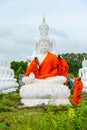 Monks dressing one of White Buddha Image with robes