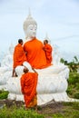 Monks dressing one of White Buddha Image with robes