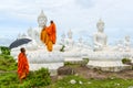 Monks dressing one of White Buddha Image with robes