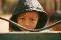 Sa Pa, Vietnam - January 16, 2018: Portrait of young poor Vietnamese boy on a street near to fence