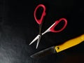 Scissor and a small knif in a black background Royalty Free Stock Photo