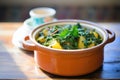 saag aloo in a ceramic pot on a wooden table Royalty Free Stock Photo
