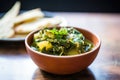 saag aloo scooped with a piece of naan bread Royalty Free Stock Photo