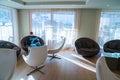 Young man sitting in a chair reading a book in a comfortable library room near huge windows. Royalty Free Stock Photo