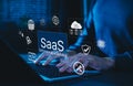 SaaS Software as a Service Digital Cloud Technology. Hands typing on laptop with SaaS icons representing cloud computing, data Royalty Free Stock Photo