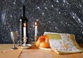 Sabbath image. challah bread and candelas on wooden table. glitter overlay