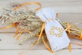 Sachet with ukrainian embroidery, wheat and oat on wooden background