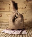 A sack of burlap stands on paper money. 500 rubles of Russian money. Money on a bamboo carpet