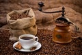 Sack of coffee beans, white cup and coffee grinder