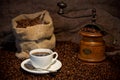 Sack of coffee beans, white cup and coffee grinder Royalty Free Stock Photo