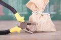 A sack of funds and a pair of pliers holding a Swiss franc in front of a blackboard with financial graphics