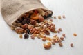 Sackcloth bag with mix of nuts and dried fruits on light background Royalty Free Stock Photo
