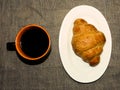 Mug of black coffee and a croissant on a white plate Royalty Free Stock Photo