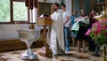 The sacrament of baptism. Christening the baby. Child, priest and parishioners