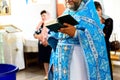 The sacrament of baptism. Orthodoxal Christening. Priest with ritual attributes