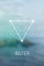 Sacred geometry Water element symbol inside Metatron Cube and Flower of Life in front of natural blurry background