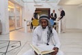In the sacred month of Ramadan, an African American Muslim man engrossed in reading the Holy Quran is surrounded by a
