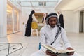 In the sacred month of Ramadan, an African American Muslim man engrossed in reading the Holy Quran is surrounded by a