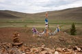 Sacred pillars with ribbons for shamanistic rites on a background of hills. Royalty Free Stock Photo