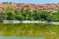 Sacred pond associated with Ramayana against a backdrop of boulders in Hampi, India