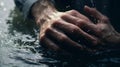 Hands praying in water at christian baptism