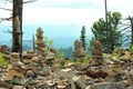 Sacred stone pyramids, young pine trees and dry tree trunks on a hilltop overlooking the mountain ranges