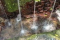 Sacred water springs in the Pakerisan Valley at the Tampaksiring Burial Complex. Gunung Kawi, Bali, Indonesia. Water falls on