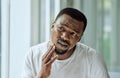 Sad, aesthetic and anxiety of black man with acne confused with face analysis in home bathroom mirror. Unhappy skincare Royalty Free Stock Photo