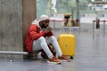 Exhausted African man on a long night connection at airport, waiting for a plane sitting in terminal Royalty Free Stock Photo