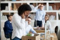 Sad african female employee packing belongings in box got fired