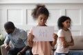 Sad african girl holding family picture upset about parents divorce Royalty Free Stock Photo