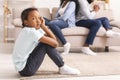 Sad african girl sitting separately from parents after their conflict Royalty Free Stock Photo