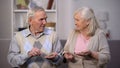 Sad aged couple holding coins looking each other, social insecurity, poverty Royalty Free Stock Photo